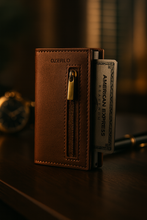 Load image into Gallery viewer, Brown leather wallet with a gold zipper and an American Express card on a dark surface.