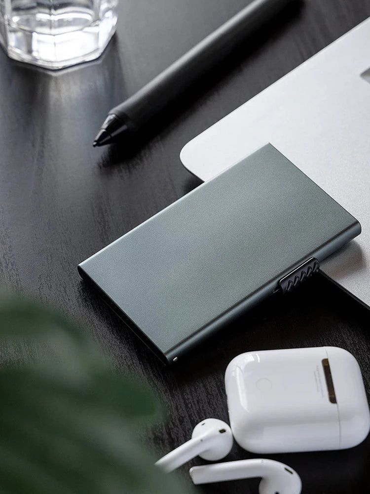 Ozerlo SlimPocket Wallet on a desk with everyday essentials, showing a slim metal card holder for modern daily carry