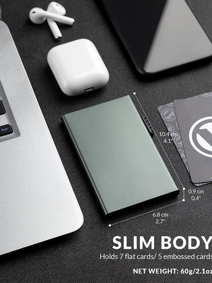 Ozerlo SlimPocket Wallet showing slim body dimensions with cards, laptop and wireless earbuds on a desk