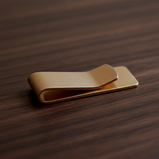Gold money clip on a textured black surface