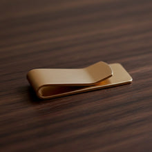 Load image into Gallery viewer, Gold money clip on a textured black surface