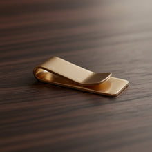 Load image into Gallery viewer, Gold money clip on a wooden surface